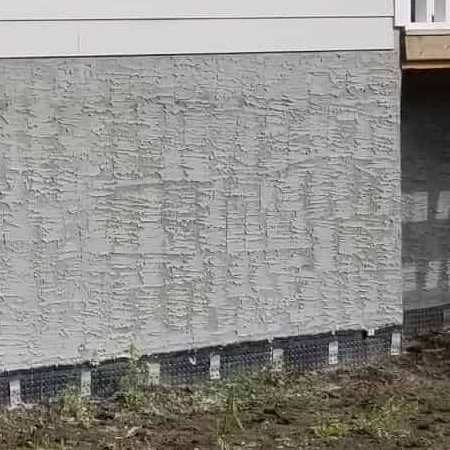 ICF parging installation on insulated concrete foundation with textured finish, showcasing energy-efficient construction and durability.
